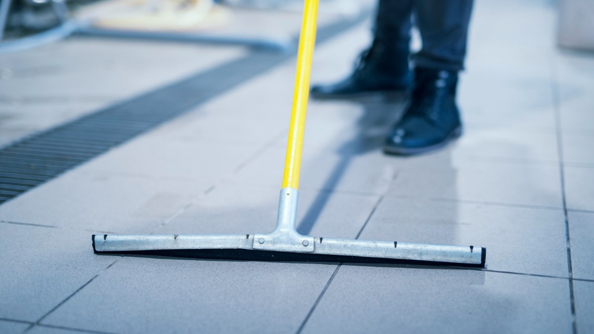 Sol humide en zone de plonge avec chaussures antidérapantes en restauration.