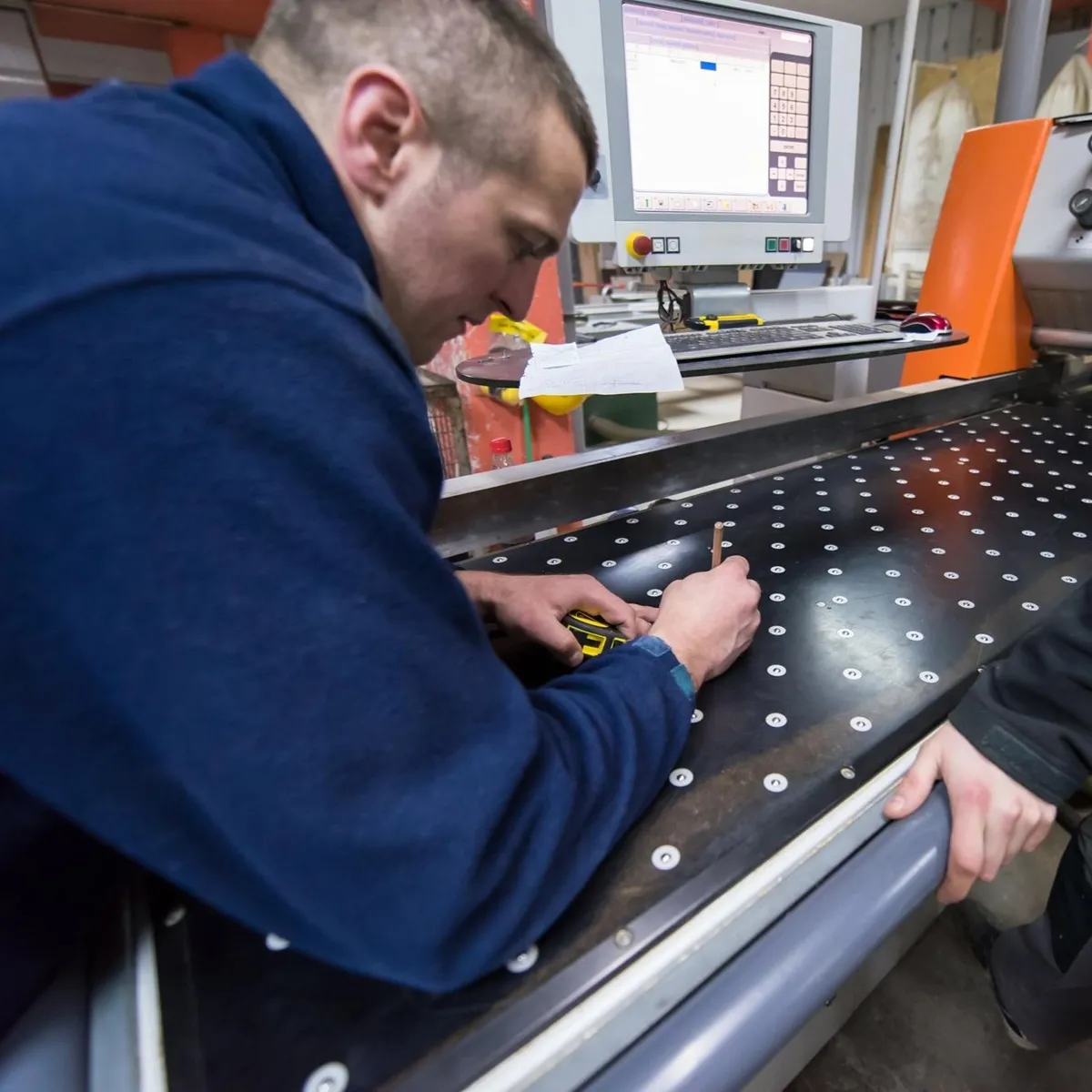 Un opérateur sur un poste de marquage industriel intégré dans un flux de production mécanique
